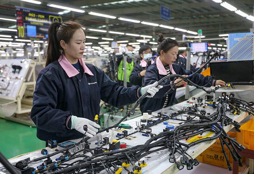 Agentes nativos de GlobalPorteX auditando una línea de producción en Asia